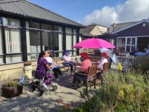 Regular Acredale attendees in garden enjoying the sunshine